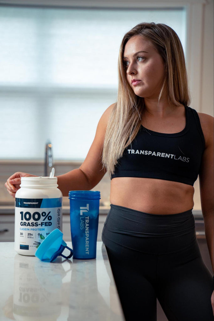 Protein shake before or after workout: Woman scooping Transparent Labs Casein protein powder