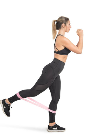 Woman doing a glute kickback with band